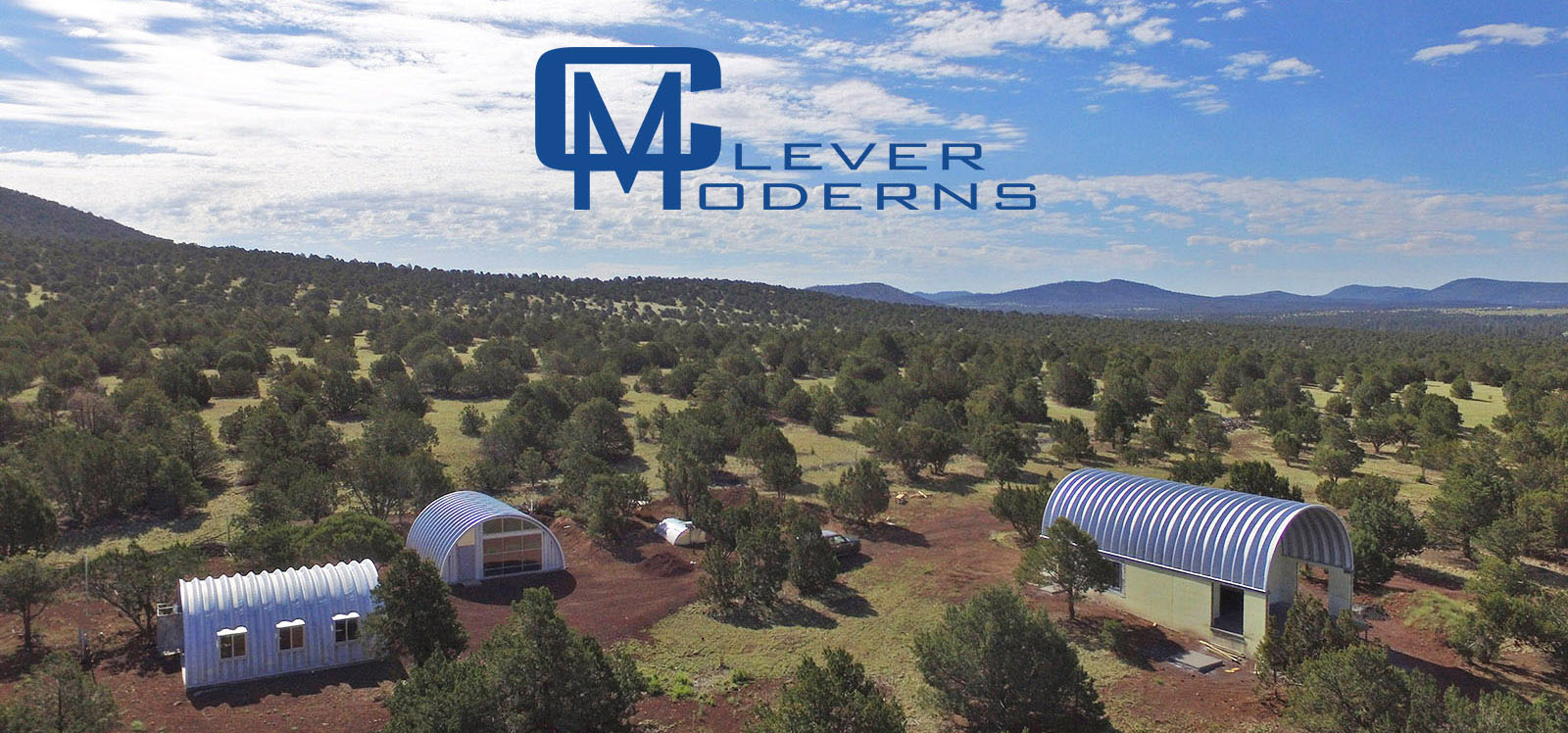 Clever Moderns Quonset Hut Resources Aerial image of mountain landscape with Quonset huts.